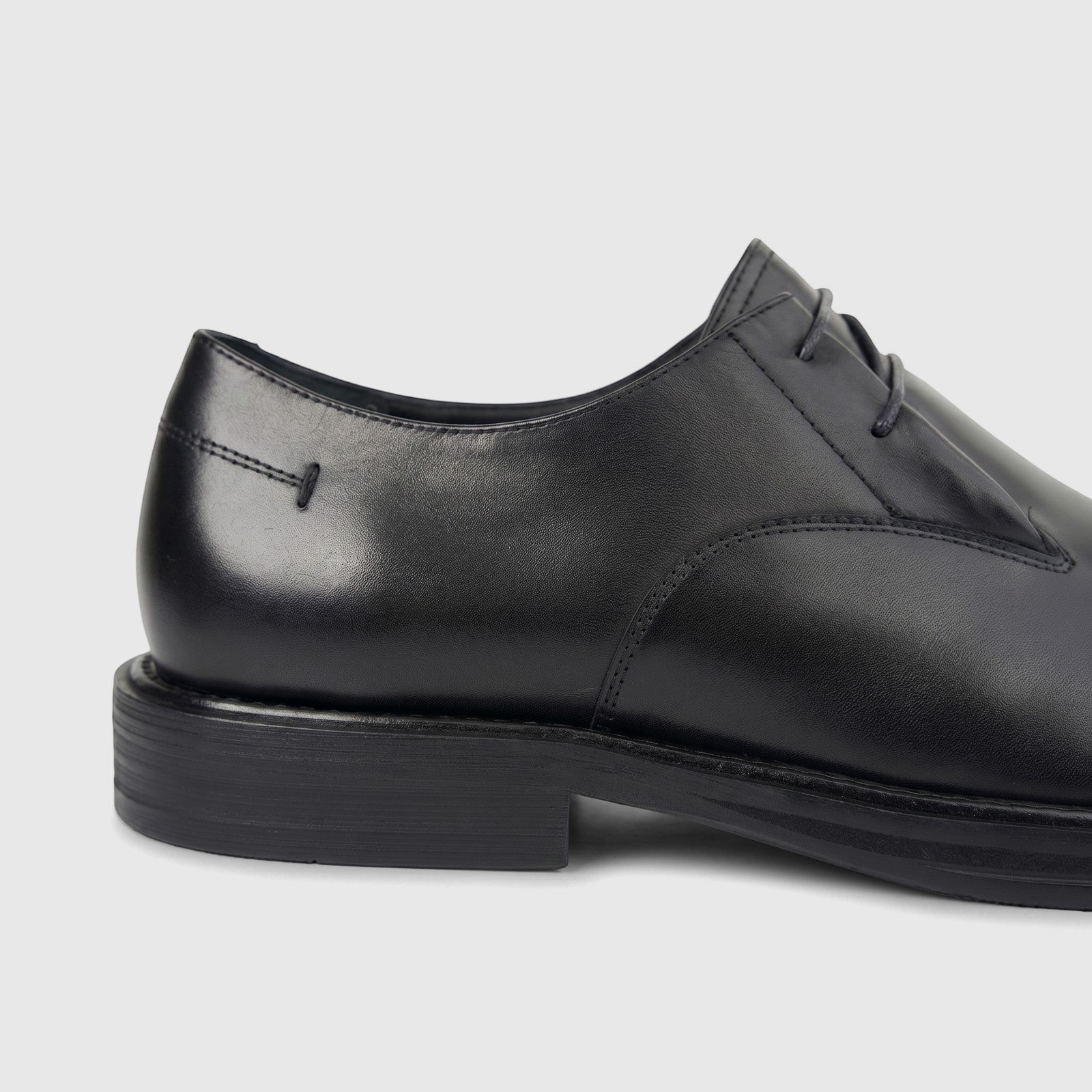 Close-up of a black Formales Men's Leather Chunky Sole Slip On shoe, showcasing the elegant leather, intricate stitching,