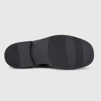 Black Formales men's chunky sole slip-on leather shoe, viewed from the underside showing the textured grip patterns and