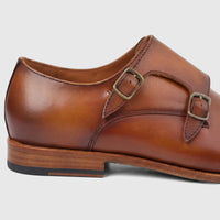 Formale's Men's Leather Double Monk Dress Slip-On shoe in brown, featuring two antique brass buckles, captured from a side