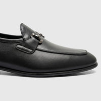 Close-up of a Formales Men's Leather Loafer in black, featuring silver-tone bit hardware on a textured leather upper.