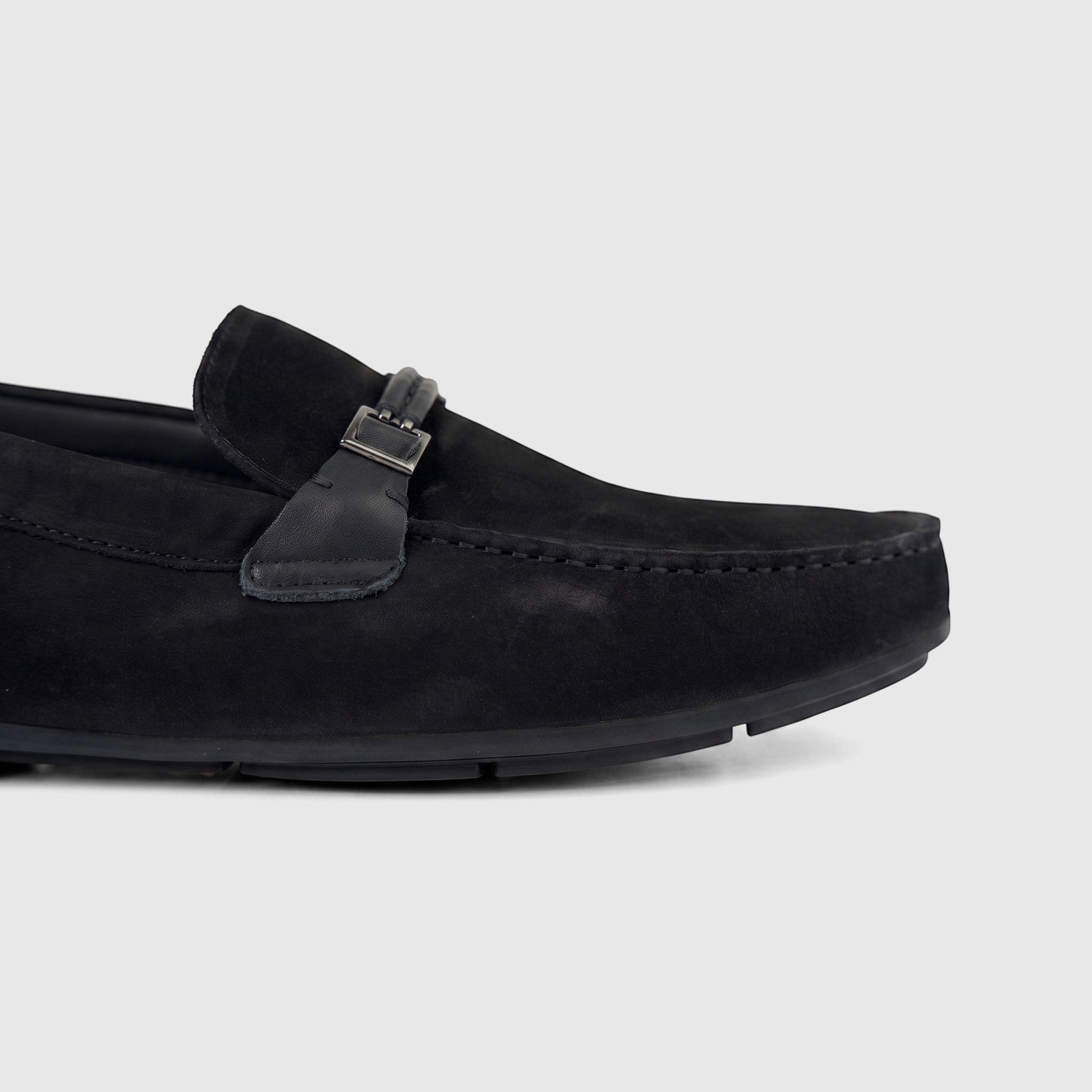Close-up side view of a Formales Men's Leather Loafer in black, featuring a sleek design with a buckle detail on the vamp.