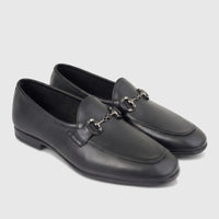 A pair of black leather men's loafers with a silver-toned metal horsebit detail, shown from a side angle.