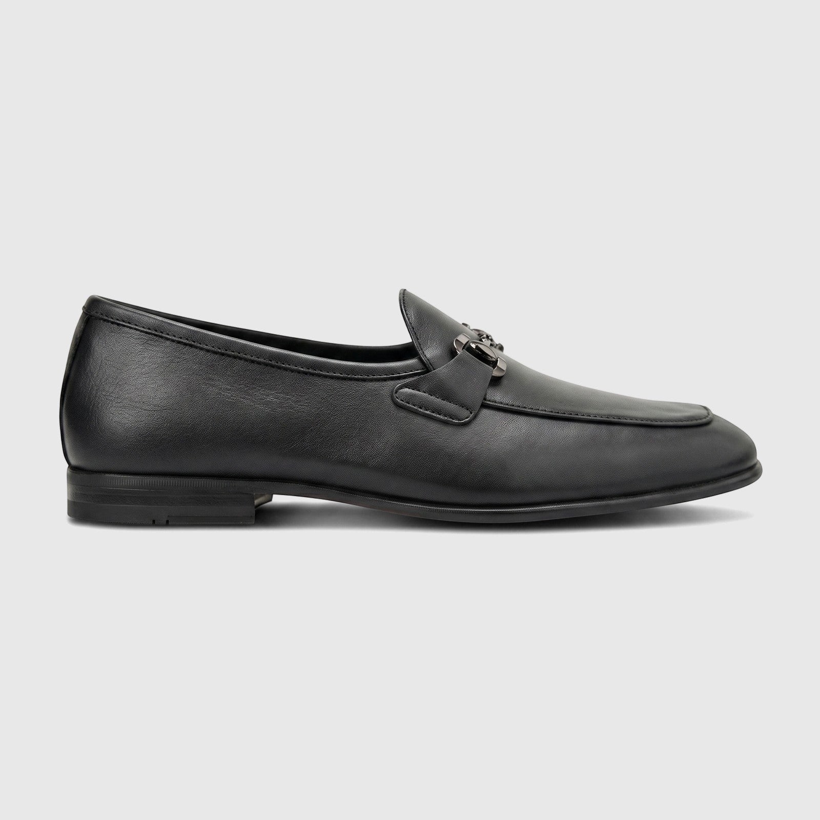Black leather men's loafers with a metal bit detail, shown in a side profile on a white background.
