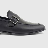 Black Formales men's leather loafer with a side buckle, shown in a close-up side view, highlighting its texture and