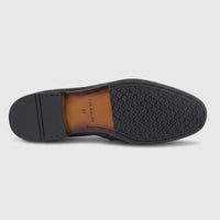 View of the black Formales men's leather loafer's sole, showcasing its patterned rubber outsole and branded brown leather