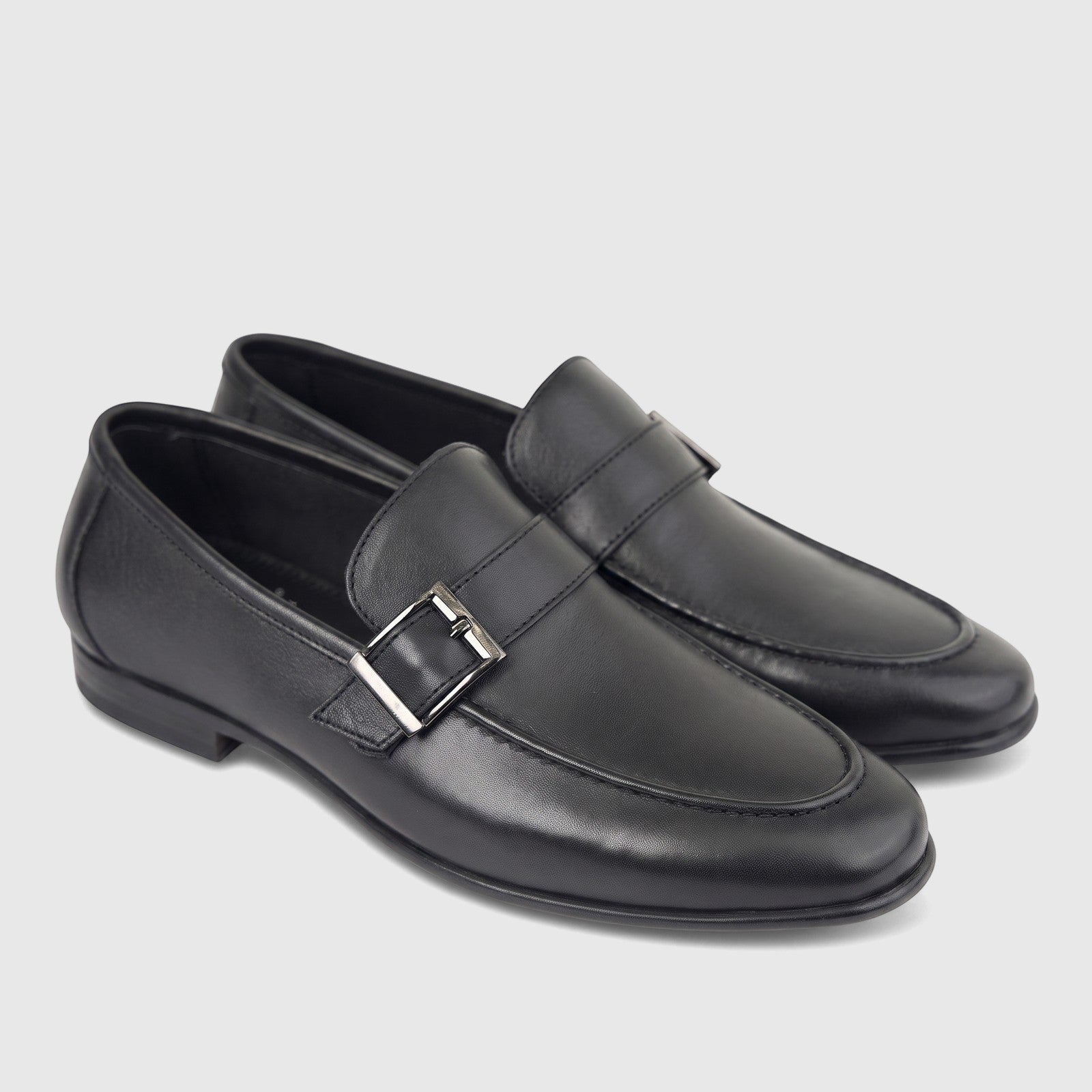 Pair of black leather men's loafers with a silver buckle detail, presented on a white background, ideal for formal wear.