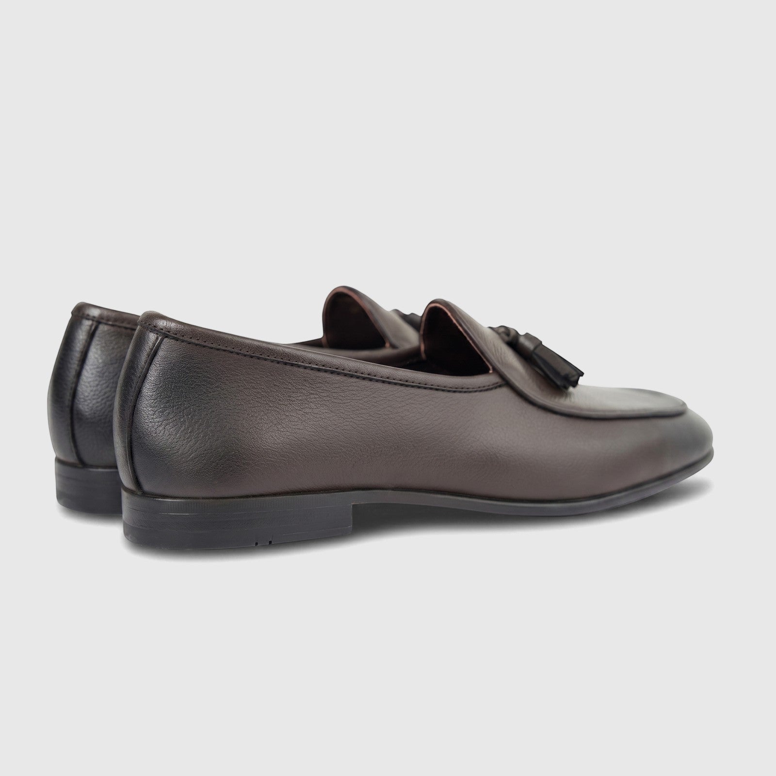 A pair of dark brown Formales Men's Leather Loafers FT268006, featuring tassels, presented from a side angle.