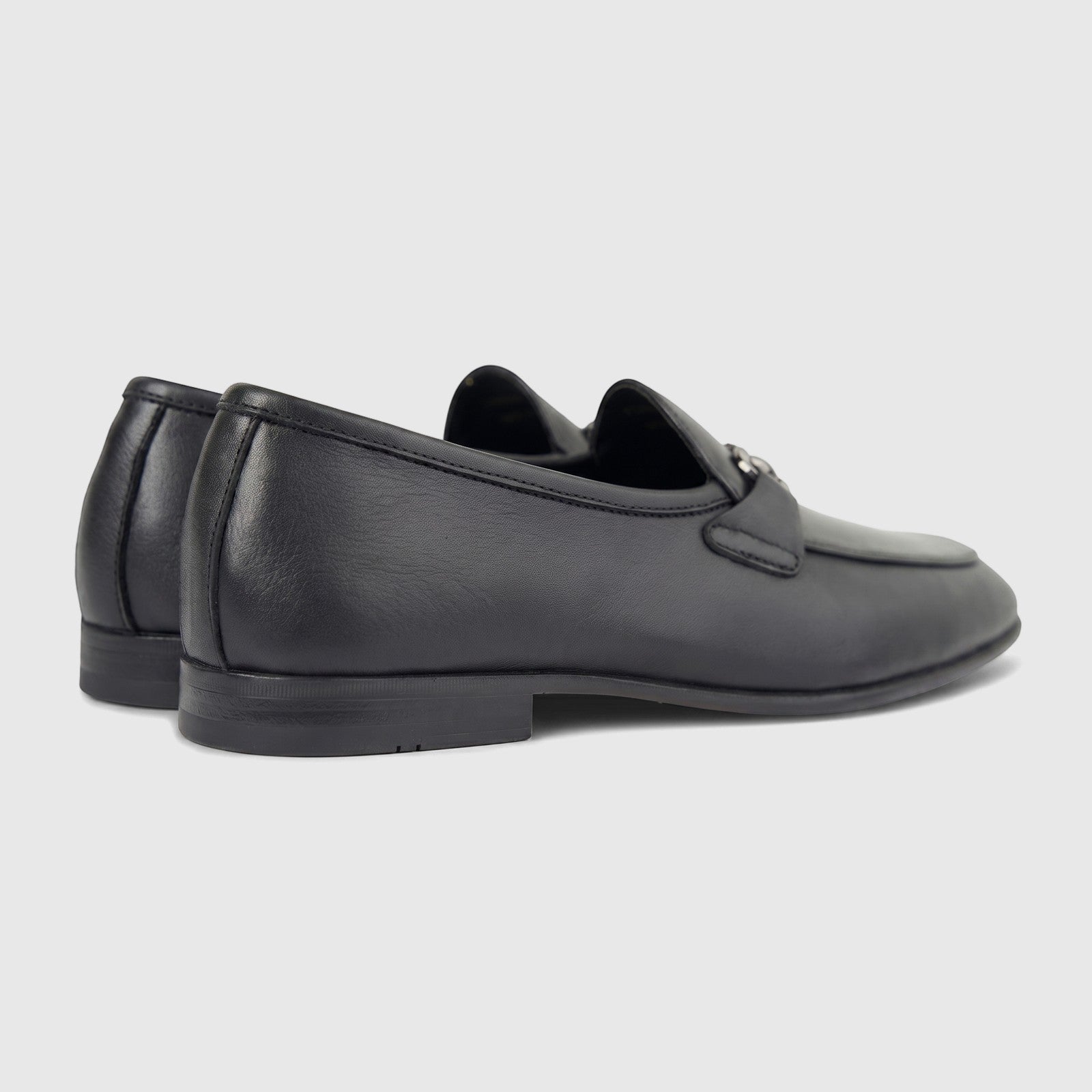 Pair of Formales Men's black leather loafers with a silver-tone bit detail, shown from a side-rear view.
