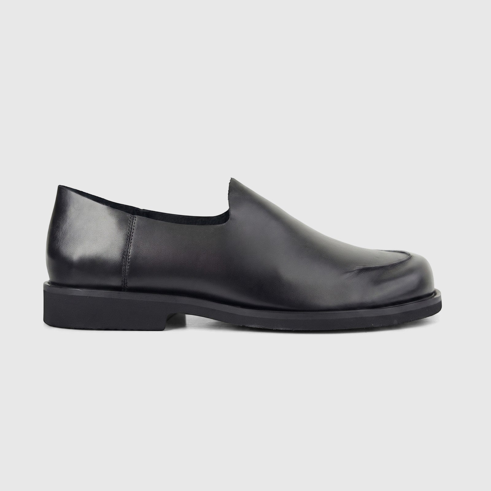 Black Formales Men's Leather Slip On shoe, with detailed stitching and a low heel, viewed from the side.