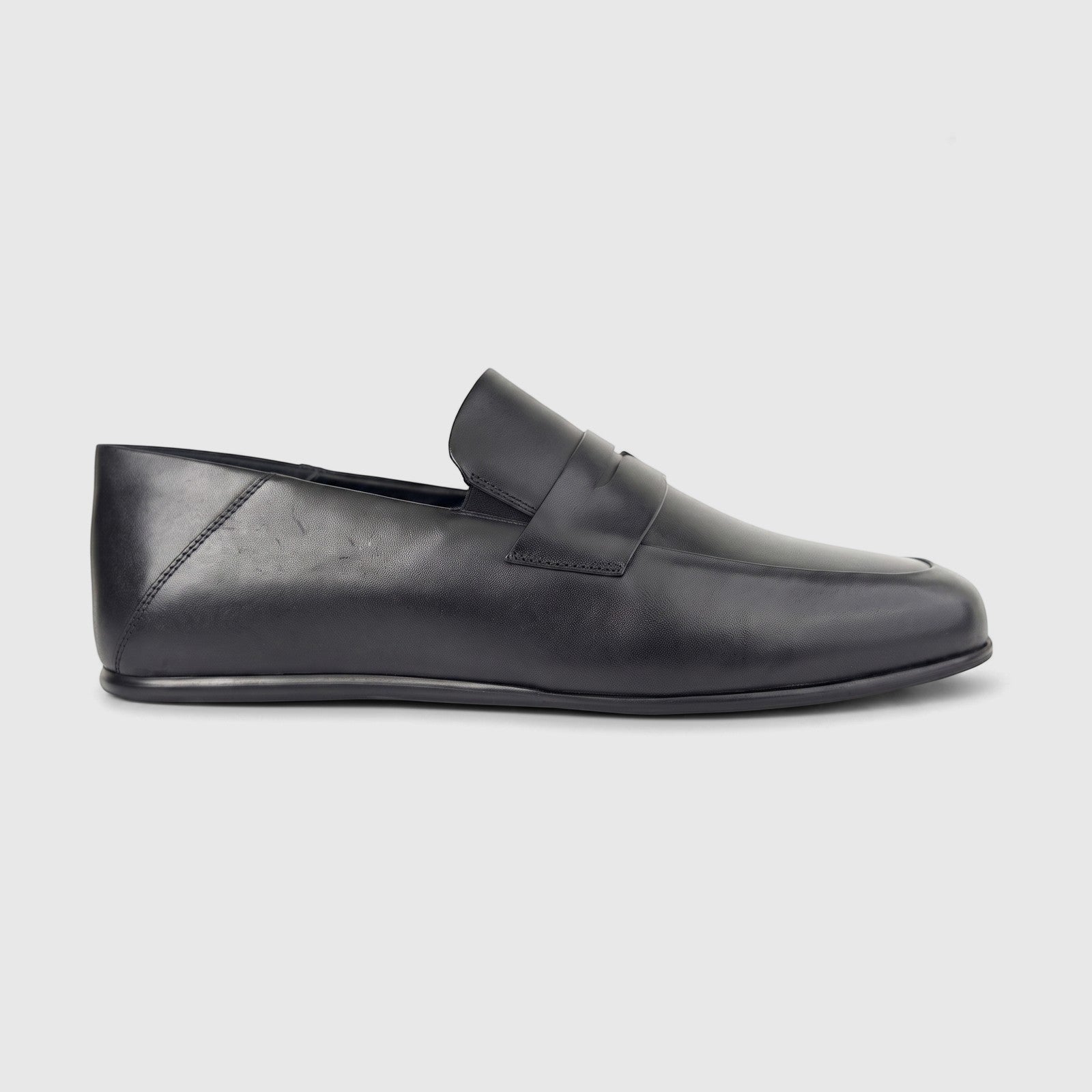Black leather slip-on loafer for men, featuring smooth texture and side profile view.