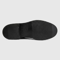 View of the black sole of a Formales men's leather slip-on shoe, featuring a textured grip pattern on a flat surface.