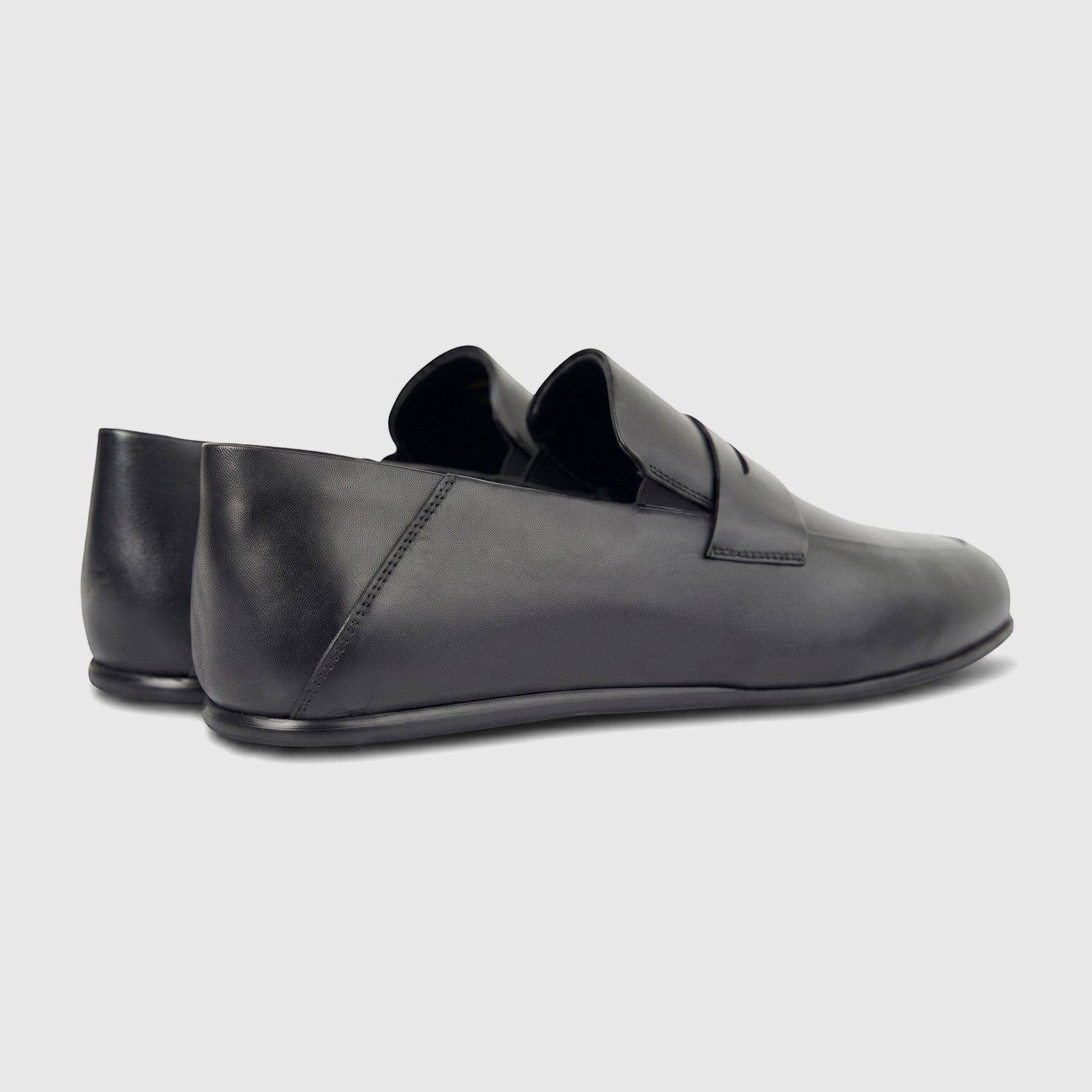 A pair of Formale's men's black leather slip-on shoes, seen from a rear-right quarter view, on a white background.