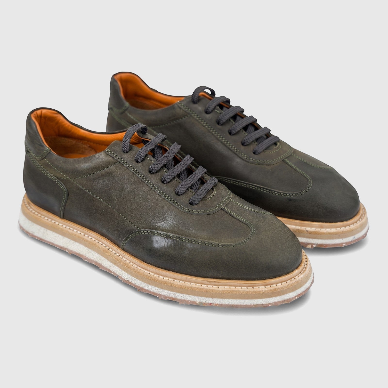 Pair of Formales men's suede sneakers in olive green, featuring dark laces, tan interior, and a multi-layered thick sole.