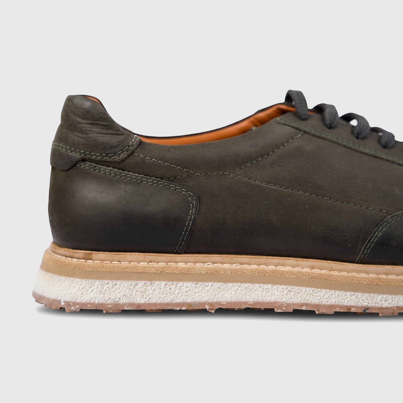 Men's Formales olive green suede sneaker with dark laces and a multi-layered sole, shown in a close-up side view.