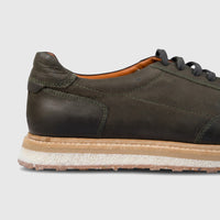 Men's Formales olive green suede sneaker with dark laces and a multi-layered sole, shown in a close-up side view.