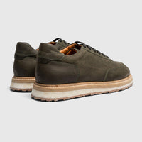 Rear-quarter view of a pair of Formales men's suede sneakers in olive green, featuring black laces and a layered sole.
