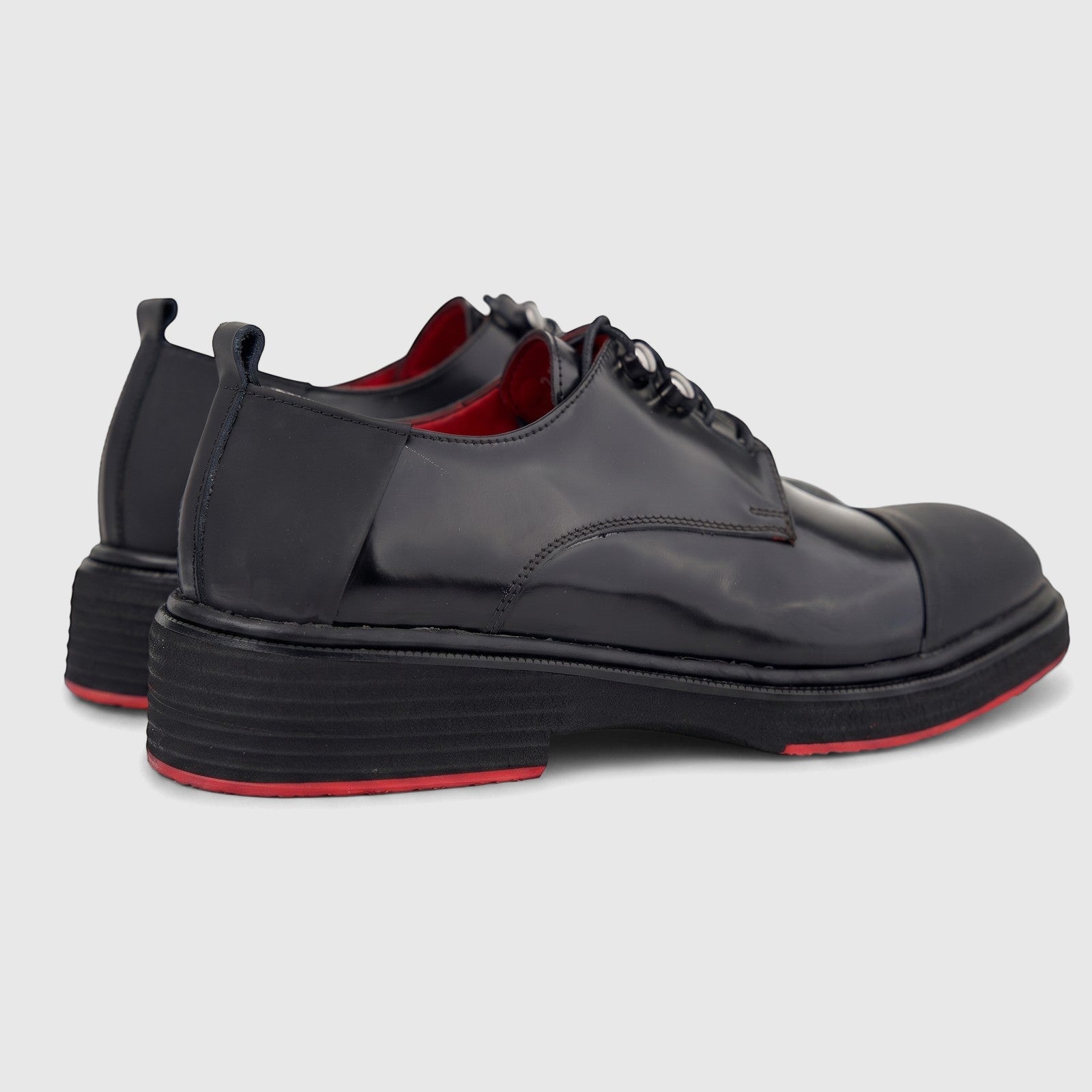 Formales men's black glossy leather lace-up shoes with chunky soles and red accents, viewed from the side-rear.