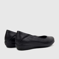 A pair of Hotter Ladies Comfort Pump Birdie in black, made from smooth leather, seen from a rear-side angle on a light