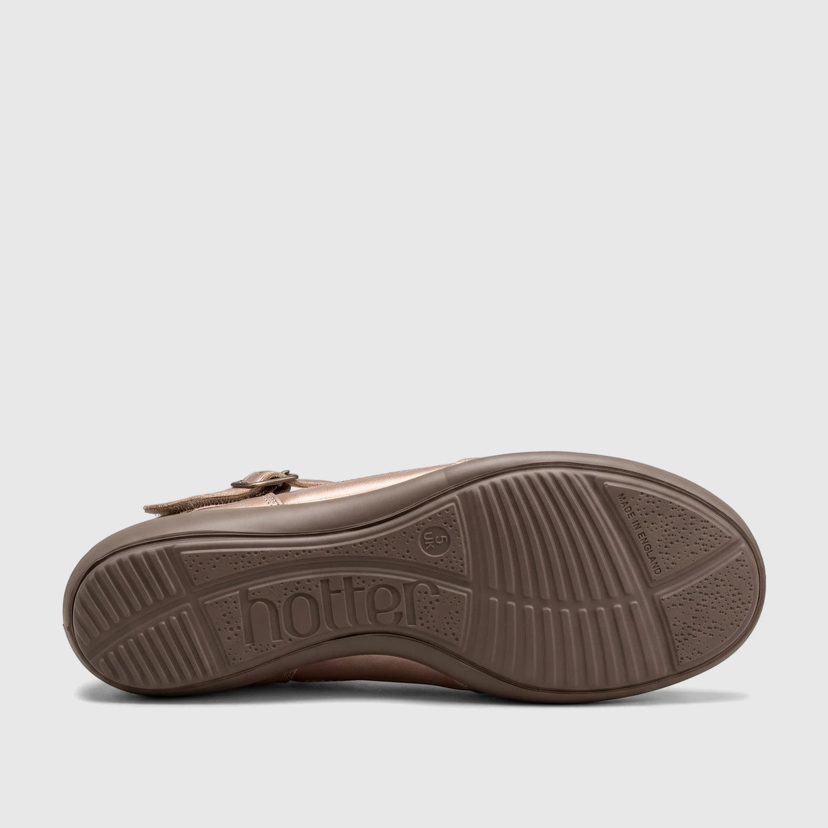 The brown rubber sole of a Hotter Ladies Comfort Pump in rosegold, viewed from the side, showing the molded 'hotter' logo