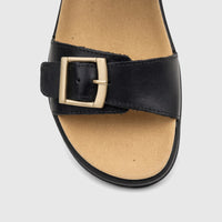 Close-up of a black leather Hotter Ladies Comfort Sandal Corfu featuring a gold buckle on the front strap and a tan insole.