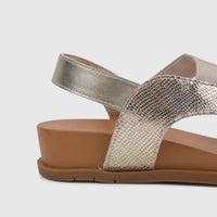 Gold metallic women's comfort sandal with snakeskin texture and a brown sole, shown from a side view.
