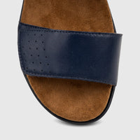 Close-up view of an HP Ladies Comfort Sandal Saria in navy blue, featuring a perforated leather strap and a brown suede-like