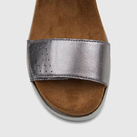 Silver metallic ladies' comfort sandal with a perforated strap and tan footbed, viewed from the front on a white background.