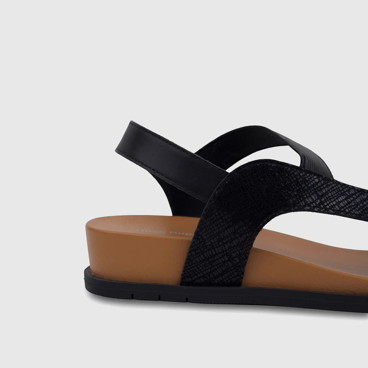 HP Ladies Comfort Sandal Zaira in black, showcasing textured straps and a tan wedge sole, captured from a side view.