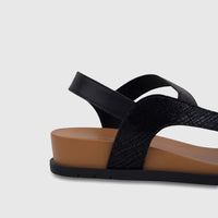 HP Ladies Comfort Sandal Zaira in black, showcasing textured straps and a tan wedge sole, captured from a side view.
