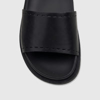 Close-up of a single black HP Ladies Comfort Slide Reya sandal with visible stitching detail on the strap, presented from a