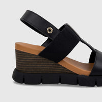 Black HP Ladies Comfort Wedge Sandal with brown footbed, striped wedge heel, and black straps, shown in a side view.