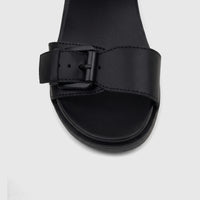 Close-up of HP Ladies Comfort Wedge Sandal Noa in black, featuring a prominent buckled strap and platform sole design.