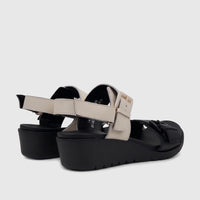 Rear view of a pair of HP Noa comfort wedge sandals featuring black soles and cream adjustable hook-and-loop straps.