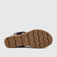 Bottom view of an HP Ladies Comfort Wedge Sandal featuring a brown sole with a zigzag pattern and a navy blue strap.
