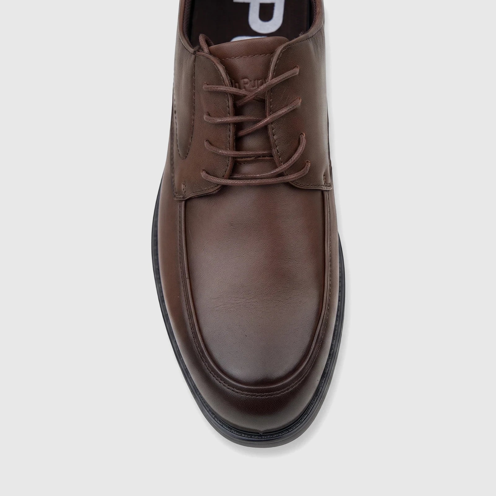Top-down view of a men's brown leather lace-up dress shoe with a black sole and intricate stitching.