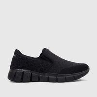 Men's black Hush Puppies slip-on comfort sneaker with a textured knit upper and segmented sole, side view.