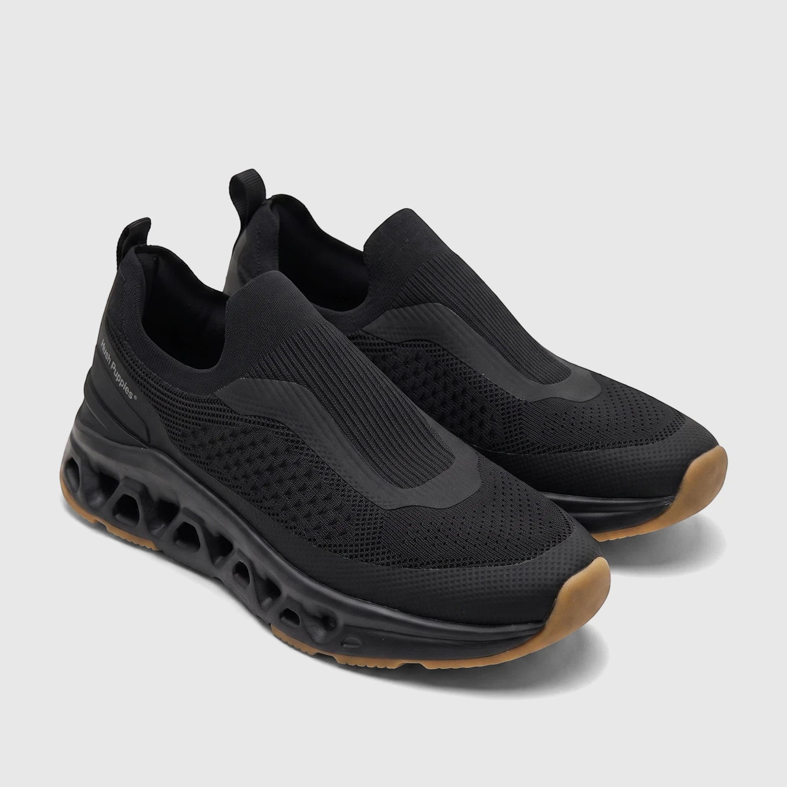 Pair of black knit HP Men's Comfort Slip On Sneaker Knoxx, featuring a sculpted sole and tan outsole, angled view.