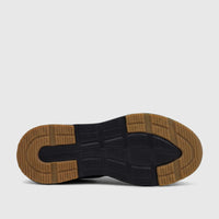 Bottom view of a black HP Men's Comfort Slip On Sneaker Knoxx with a tan traction sole, showcasing the tread pattern.