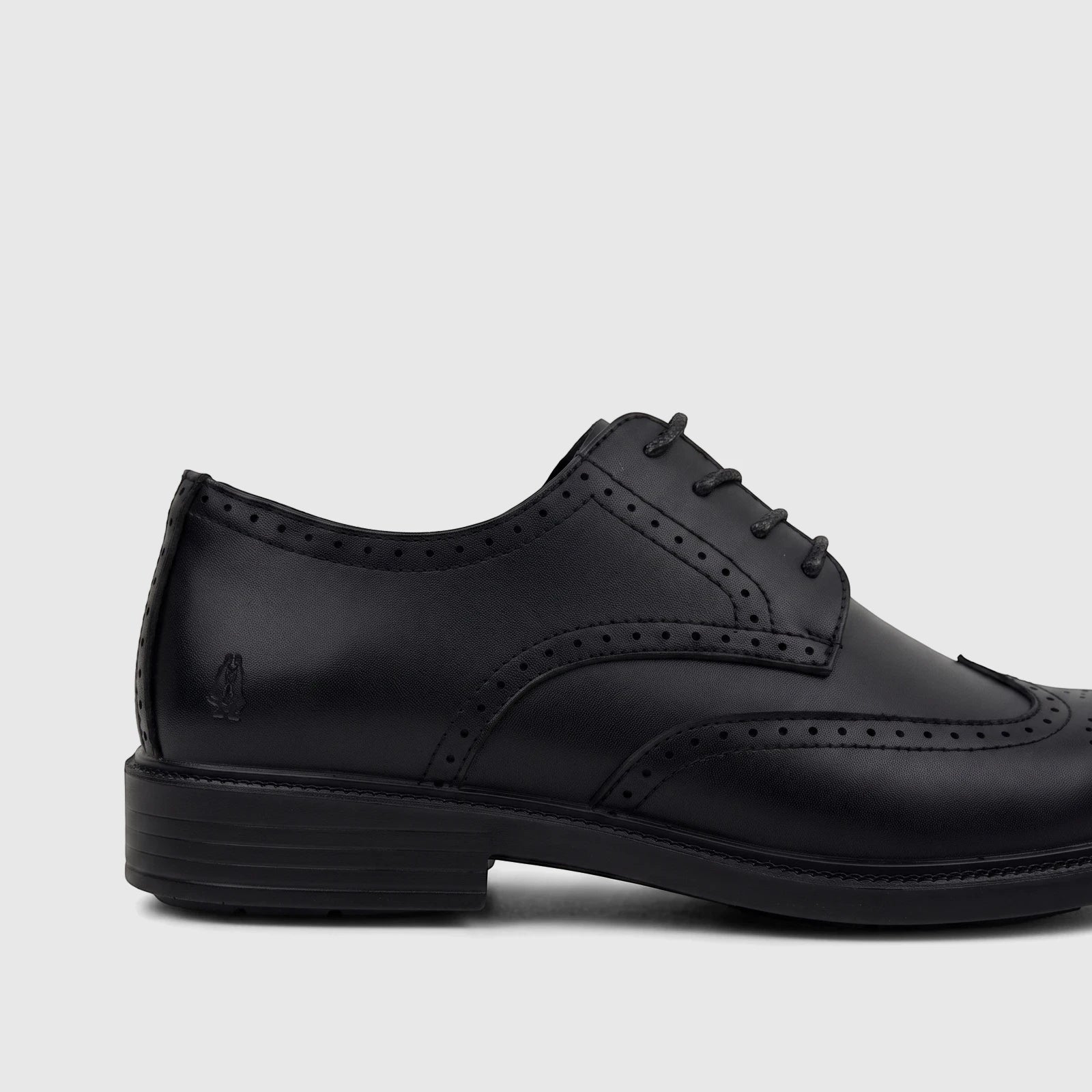 Side view of a black leather men's lace-up brogue dress shoe with detailed perforations and stitching.