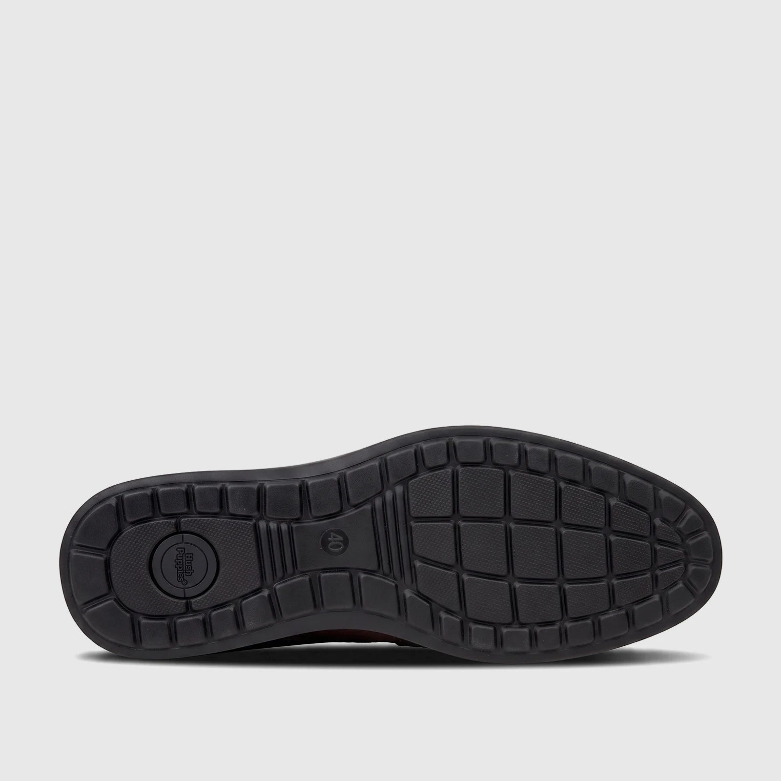 Bottom view of an HP Men's Dress Lace Up Patrick brown shoe, showing its black sole with grip pattern and Hush Puppies logo.