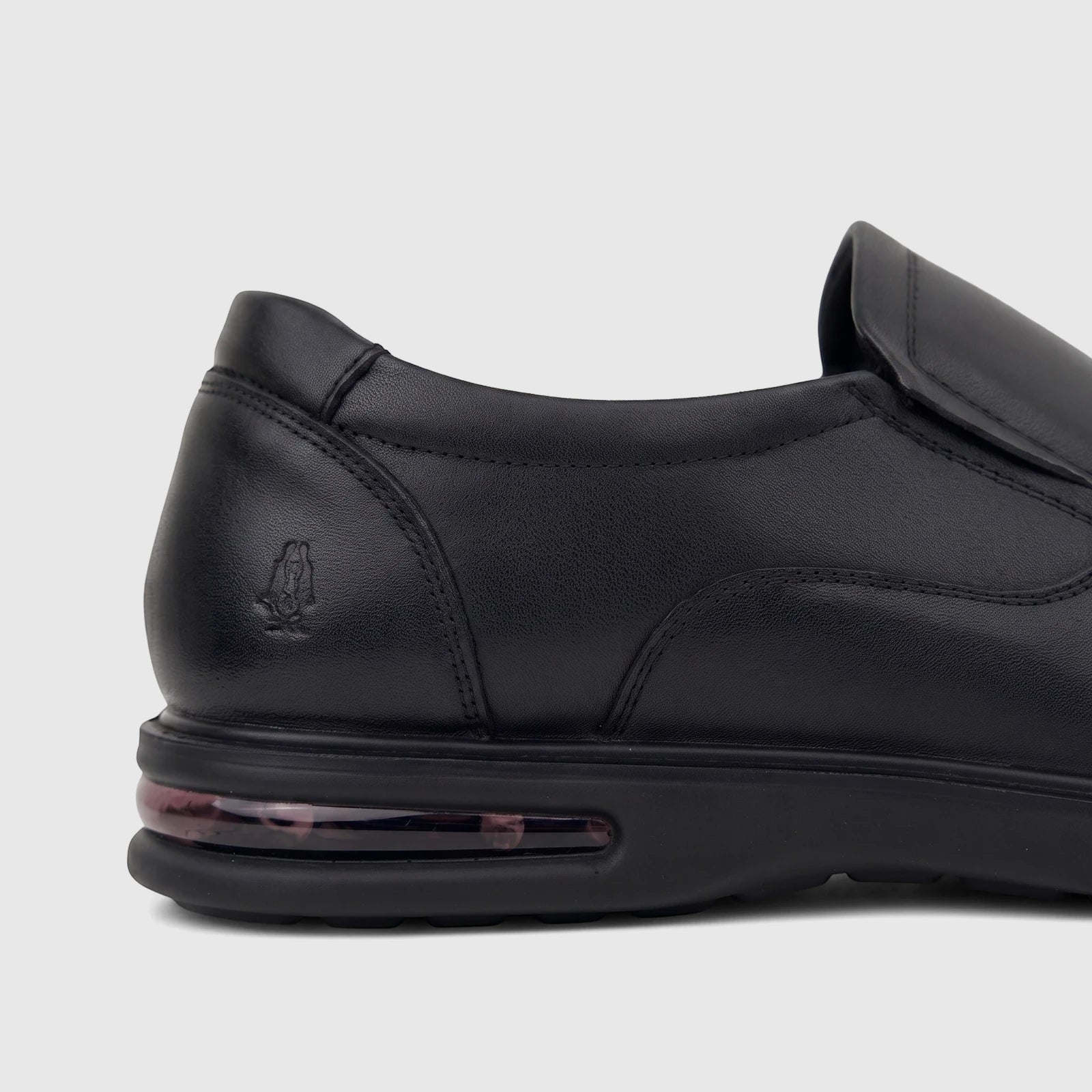 Close-up of a black leather HP Men's Dress Slip On Julian shoe, featuring the embossed Hush Puppies logo and an air cushion