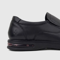 Close-up of a black leather HP Men's Dress Slip On Julian shoe, featuring the embossed Hush Puppies logo and an air cushion