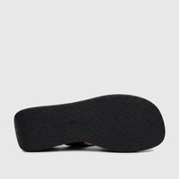 Underside view of an HP Soft Style Jemma black leopard print wedge sandal, featuring a textured black sole and dark brown