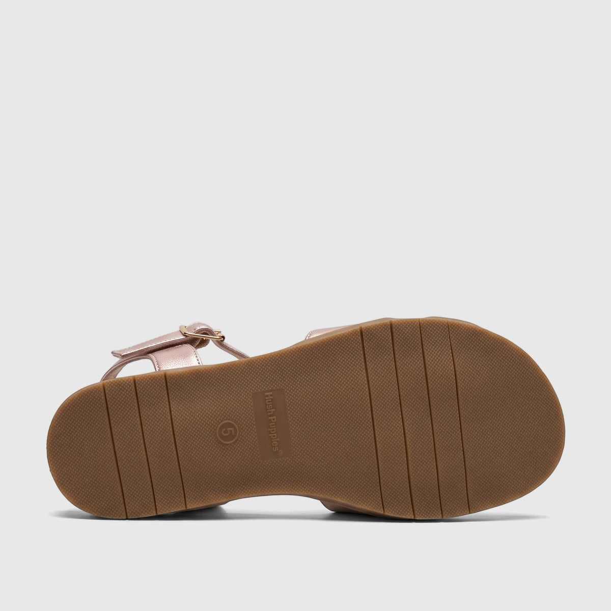 Bottom view of a Hush Puppies Baby Ines HPL01521 women's comfort sandal in pink metallic, featuring a brown textured sole