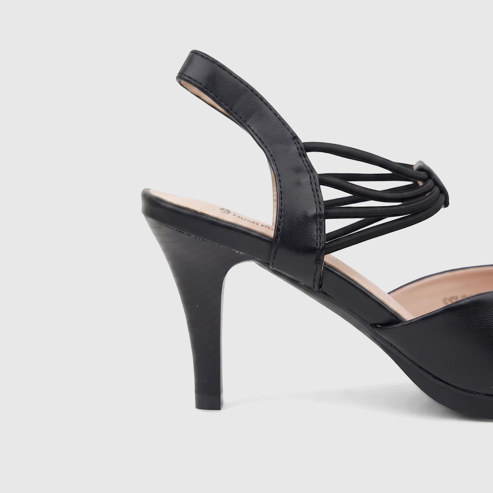 Hush Puppies Soft Style black high-heeled court shoe with elastic ankle strap, shown from a side view.