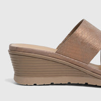 Close-up view of a bronze metallic Hush Puppies Soft Style ladies comfort wedge sandal, featuring a wide strap and textured