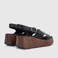 Black Hush Puppies Soft Style Jemma comfort wedge sandals featuring black leather straps and a wood-look platform.