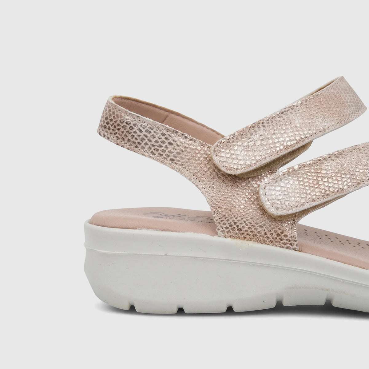 A light gold snakeskin-textured Hush Puppies ladies' comfort sandal with a white platform sole and velcro straps, viewed
