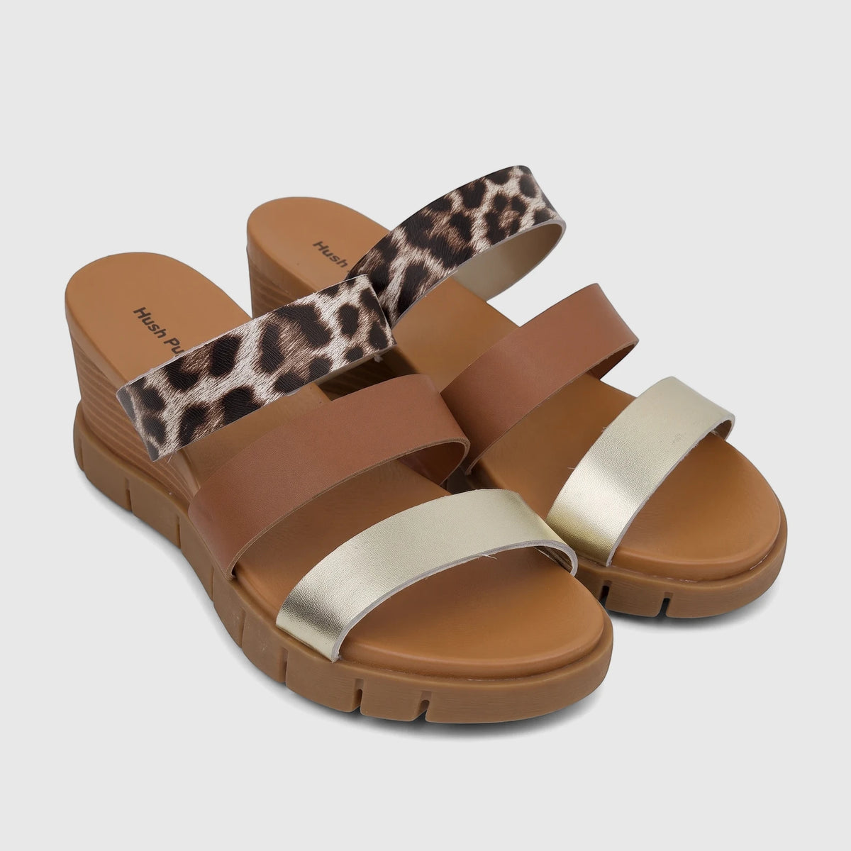 Pair of Hush Puppies Ladies Comfort Wedge Sandals with leopard print, brown, and gold straps, and a brown wedge sole.