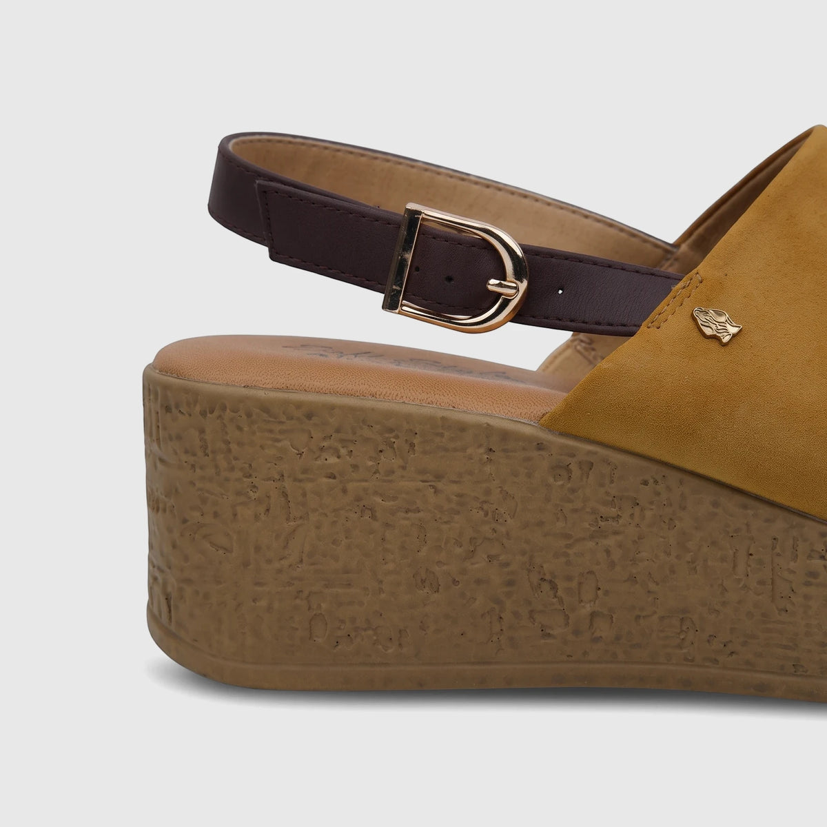Close-up of a yellow Hush Puppies Soft Style ladies comfort wedge sandal with a brown strap and gold buckle.